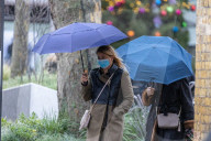 Members of the public brave the rain while shopping London.