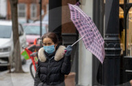 Members of the public brave the rain while shopping London.