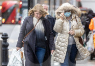 Members of the public brave the rain while shopping London.