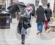 Members of the public brave the rain while shopping London.