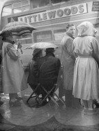 THEY WAIT TO SEE KING 'S CORTEGE             11-02-52              PHOTO SHOWS:- Seated on folding stools these people were waiting outside London's Kings Cross Station to see the  funeral procession. The King's coffin was arriving at Kings Gross from Wol