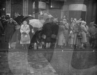 THEY WAIT IN THE RAIN FOR KING'S FUNERAL  PROCESSION 11-2-52     PHOTO SHOWS:- Umbrellas and mackintoshes were much in use by people who lined the route for the King's funeral procession through London to Westminster Hall today. Here is a scene outside Ki