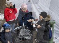 Ukrainian civilians who have fled the Russian invasion cross the border into Poland at Kroscienko.
