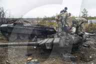 NEWS - Ukraine-Krieg: Ukrainische Soldaten inspizieren einen zerstörten russischen Panzer bei Kiew