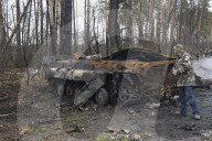 NEWS - Ukraine-Krieg: Ukrainische Soldaten inspizieren einen zerstörten russischen Panzer bei Kiew