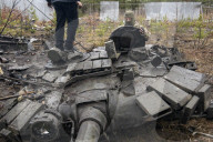 NEWS - Ukraine-Krieg: Ukrainische Soldaten inspizieren einen zerstörten russischen Panzer bei Kiew