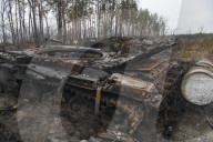 NEWS - Ukraine-Krieg: Ukrainische Soldaten inspizieren einen zerstörten russischen Panzer bei Kiew