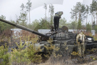NEWS - Ukraine-Krieg: Ukrainische Soldaten inspizieren einen zerstörten russischen Panzer bei Kiew