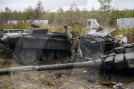 NEWS - Ukraine-Krieg: Ukrainische Soldaten inspizieren einen zerstörten russischen Panzer bei Kiew