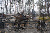 NEWS - Ukraine-Krieg: Ukrainische Soldaten inspizieren einen zerstörten russischen Panzer bei Kiew