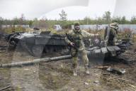 NEWS - Ukraine-Krieg: Ukrainische Soldaten inspizieren einen zerstörten russischen Panzer bei Kiew