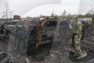 NEWS - Ukraine-Krieg: Ukrainische Soldaten inspizieren einen zerstörten russischen Panzer bei Kiew
