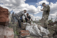NEWS - Ukraine-Krieg: Männer ziehen die Leiche eines toten russischen Soldaten aus einem Hinterhof in Malaya Rohan