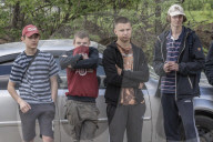 NEWS - Ukraine-Krieg: Männer ziehen die Leiche eines toten russischen Soldaten aus einem Hinterhof in Malaya Rohan