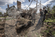 NEWS - Ukraine-Krieg: Männer ziehen die Leiche eines toten russischen Soldaten aus einem Hinterhof in Malaya Rohan