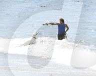 Sean Stewart is seen out for a walk on the beach in Malibu with his dog and a mystery woman, the day after 4th of July celebration. 