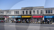 Mopeds are lined up along Wimbledon Broadway with delivery drivers waiting