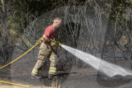 Firefighters put out a grass fire at Hollow Ponds in Leytonstone, East London.