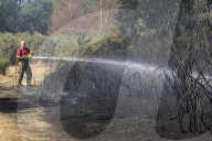 Firefighters put out a grass fire at Hollow Ponds in Leytonstone, East London.