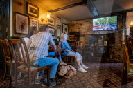 ROYALS - Trauer um die Queen: Menschen schauen sich im Pub die TV Übertragung der Prozession an