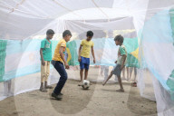 FEATURE - Strassenkinder in Kalkutta spielen Fussball in einem Moskitonetz während eines Aufklärungsprogramms zur Dengue-Prävention