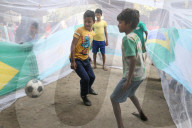 FEATURE - Strassenkinder in Kalkutta spielen Fussball in einem Moskitonetz während eines Aufklärungsprogramms zur Dengue-Prävention
