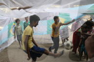 FEATURE - Strassenkinder in Kalkutta spielen Fussball in einem Moskitonetz während eines Aufklärungsprogramms zur Dengue-Prävention