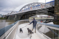Public enjoy the views of the river Thames from footbridge that goes under the grade II listed Barnes Railway Bridge in south-west London.