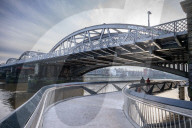 Public enjoy the views of the river Thames from footbridge that goes under the grade II listed Barnes Railway Bridge in south-west London.