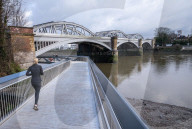 Public enjoy the views of the river Thames from footbridge that goes under the grade II listed Barnes Railway Bridge in south-west London.