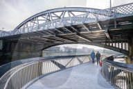 Public enjoy the views of the river Thames from footbridge that goes under the grade II listed Barnes Railway Bridge in south-west London.
