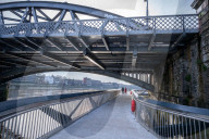 Public enjoy the views of the river Thames from footbridge that goes under the grade II listed Barnes Railway Bridge in south-west London.