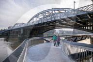 Public enjoy the views of the river Thames from footbridge that goes under the grade II listed Barnes Railway Bridge in south-west London.