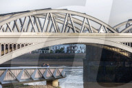 Public enjoy the views of the river Thames from footbridge that goes under the grade II listed Barnes Railway Bridge in south-west London.