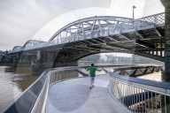 Public enjoy the views of the river Thames from footbridge that goes under the grade II listed Barnes Railway Bridge in south-west London.
