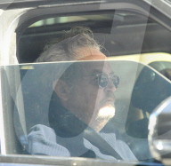 Matthew Perry looks disheveled and solemn as he puffs on a cigarette whilst being chauffeur driven to a tennis club on the afternoon of January 25, 2023. 