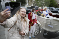 Coronation look-a-likes ride a carriage through central London.