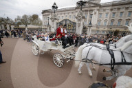 Coronation look-a-likes ride a carriage through central London.