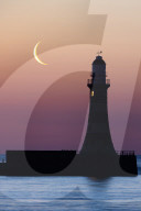 FEATURE -  Fotograf faengt 9 % Mondsichel gegen einen pastellfarbenen Himmel ueber dem Leuchtturm von Sunderland ein