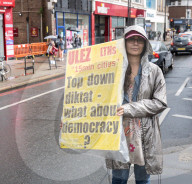 Anti-ULEZ protestors in Tooting Broadway London, Great Britain 
26th August 2023 

People campaigning to stop the ULEZ expansion which is due to commence on 29th August 2023 hold placards towards the traffic around Tooting Broadway
