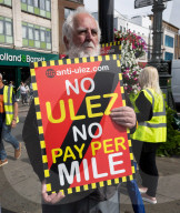 Anti-ULEZ protestors in Tooting Broadway London, Great Britain 
26th August 2023 

People campaigning to stop the ULEZ expansion which is due to commence on 29th August 2023 hold placards towards the traffic around Tooting Broadway