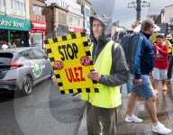 Anti-ULEZ protestors in Tooting Broadway London, Great Britain 
26th August 2023 

People campaigning to stop the ULEZ expansion which is due to commence on 29th August 2023 hold placards towards the traffic around Tooting Broadway