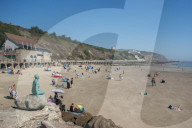Beachgoers Enjoy Sunny Sands in Folkestone, UK.
