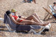 Sunbathers and swimmers on Brighton beach East Sussex, UK.