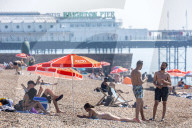 Sunbathers and swimmers on Brighton beach East Sussex, UK.