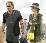 French singer Johnny Hallyday walks hand in hand with his wife Laeticia around Coachella music festival in Indio