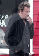 Looking a little worse for wear, French singer Johnny Hallyday pops out for a cigarette while having lunch