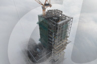 FEATURE - Nebel zieht an einem im Bau befindlichen Wolkenkratzer in Nanjing in Jiangsu vorbei