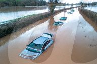 NEWS - UK: A column 11 of abandoned vehicles lay submerged on The A443 road near the small hamlet of Lindridge