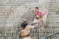 FEATURE - Arbeiterinnen und Kinder stapeln Ziegelsteine zum Brennen in Bangladesch